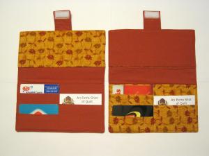 Inside of two wallets showing orange patterned fabric and reddish orange fabric.