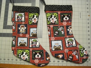 Red and black Christmas stockings featuring winter puppies
